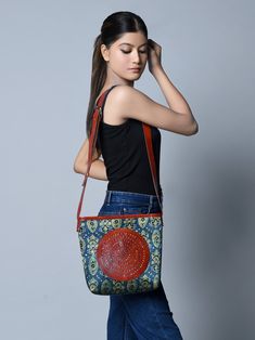 With a captivating blend of tradition and modernity, our Ajrakh Leather Tote Bag is surely a head-turner. Authentic Ajrakh motifs adorn silk fabric, framed by durable leather borders, creating an ethnic masterpiece. The circular brown leather patchwork on the front adds a unique touch. With adjustable leather handles, it transforms effortlessly from a crossbody to a shoulder bag, ensuring versatility in style. The spacious central compartment accommodates books, journals, and even laptops, makin Traditional Brown Leather Shoulder Bag, Traditional Brown Bags For Daily Use, Traditional Brown Rectangular Shoulder Bag, Traditional Brown Shoulder Bag For Everyday Use, Traditional Brown Bag For Festivals, Traditional Leather Shoulder Bag, Brown Shoulder Bag For Travel And Festivals, Traditional Leather Shoulder Bag With Embossed Detail, Traditional Red Bags With Leather Handles