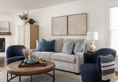 a living room filled with furniture and a fire place in front of a wall mounted painting