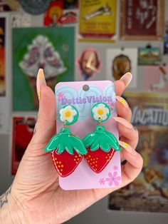 Sweet as summertime! These handmade strawberry earrings are super shiny and cute to boot!  Handmade with polymer clay, delicately painted details, and a hard resin coating, these babies are made to last! The backs feature a flash of gold leaf to add to the sparkly mystique!  These vintage-inspired stud-style dangly earrings have stainless steel postbacks. Need a hook instead? Just reach out and I'll be happy to swap out the post for a fishhook-style or clip-on finding instead. Each pair is hand sculpted and unique, the pair you receive may vary every-so-slightly from the picture.  Clean with warm water and a soft cloth. Avoid harsh chemicals (like rubbing alcohol) which may damage the finish. Cute Green Hand Painted Jewelry, Cute Hand Painted Earrings For Gift, Cute Summer Flower Earrings For Gifts, Cute Summer Flower Earrings For Gift, Cute Summer Flower Earrings Gift, Cute Hand Painted Earrings As Gift, Cute Hand Painted Red Jewelry, Cute Red Hand Painted Jewelry, Cute Hand Painted Resin Earrings