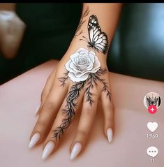 a woman's hand with tattoos on it and a white rose in the middle