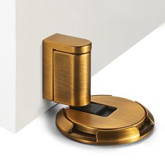 a close up of a door handle on a white wall with a metal object in the middle