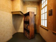 an empty room with bookshelves and windows