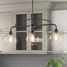 three light fixtures hanging from the ceiling in a kitchen