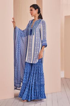 Blue embroidered crepe kurta with floral patterns. Comes with tiered sharara and a georgette dupatta, adorned with delicate lace and a printed border.
Components: 3
Pattern: Printed, Embroidered
Type Of Work: Floral
Neckline: Notched
Sleeve Type: Three Quarter
Fabric: Crepe, chiffon, georgette, chanderi
Color: Blue
Other Details: 
Tasseled neckline
Lace hem kurta
Occasion: Sangeet - Aza Fashions Blue Embroidered Sharara For Designer Wear, Blue Chikankari Embroidery Sets For Navratri, Blue Chikankari Sets For Navratri, Bohemian Traditional Wear With Dabka Work In Blue, Traditional Blue Palazzo Set, Blue Bohemian Traditional Wear With Resham Embroidery, Bohemian Blue Traditional Wear For Wedding, Blue Bohemian Traditional Wear For Wedding, Blue Bohemian Traditional Wear With Zari Work