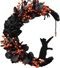 a wreath with orange berries and black cat