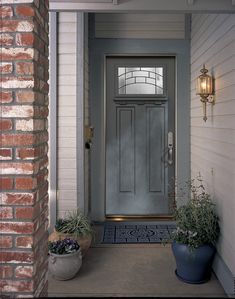 a white front door with two planters on either side