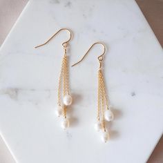 Get ready for compliments. The Pearl Dangle Earrings feature white freshwater pearls, making them perfect for special occasions (like weddings *wink*). Details: Fish hook earrings Comes packages with plastic backs Approximately 2.5 inches long Available in sterling silver or gold fill Pro Tip: Giving these earrings as a gift or wearing for a special occasion? Pair them with the Pearl Classic Necklace or Cable Chain Necklace - 14k Solid Gold for look that's practically perfect in every way. Classic White Pearl Chandelier Earrings, Dainty White Pearl Drop Chandelier Earrings, White Dangle Linear Earrings With Pearl Charm, White Linear Earrings With Ear Wire For Anniversary, White Linear Earrings For Anniversary, White Dangle Pearl Chain Earrings, Pearl White Chandelier Earrings With Pearl Charm As Gift, Pearl White Chandelier Earrings With Pearl Charm, White Pearl Linear Earrings Gift