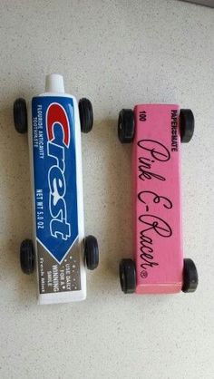 two toy cars are sitting next to each other on the table with writing on them