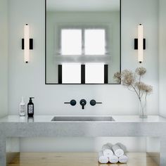 a bathroom sink with two towels on the counter next to it and a window in the background