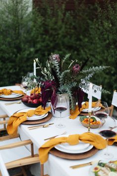 the table is set with plates and place settings