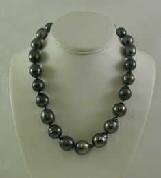 SKU # = 0471 Tahitian Pearl Necklace Pearl Size Range = 14.0 x 17.9 mm - 16.5 x 20.7 mm Number of Pearls = 23 Pearls Color of Pearls = Black with Dark Gray and slight pink tint Shape of Pearls = Baroque Gold = 14k White Gold Clasp Necklace Length including clasp = 19 inches Tahitian Pearls: These pearls are among the rarest of all pearls that are available found off the seas of Tahiti. Tahitian Pearls are natural color pearls that are very rare. They come in colors including black, gray, and gre Black Pearl Necklace With High Luster For Gift, Tahitian Pearl Necklace, Pear Shaped Ring, Black Pearl Necklace, Freshwater Pearl Ring, Jewelry Charms Pendants, Gold Rings Jewelry, Pearl Jewelry Necklace, Baroque Pearl Necklace