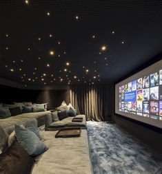 a large screen in the middle of a room with couches and pillows on it