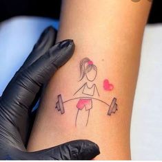 a woman's arm with a tattoo on it and a dumbble barbell