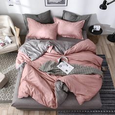 a bed with pink and grey sheets in a bedroom