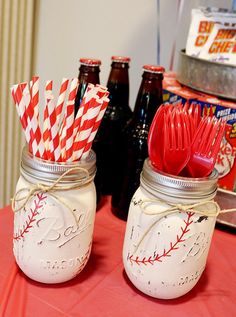 two mason jars with red and white paper straws in them are sitting on a table