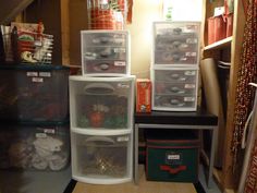 several plastic containers are stacked on top of each other in a closet with christmas decorations