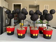 some mickey mouse cupcakes are sitting on a table with silver and black decorations