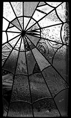 a close up of a stained glass window with drops of water on the windowsill