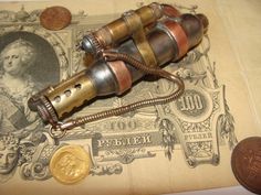 an old fashioned telescope sitting on top of a piece of paper next to a penny