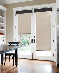 a dining room table with two chairs and a sliding glass door