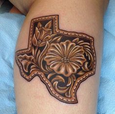 a tattoo on the leg of a person with a flower in the shape of texas