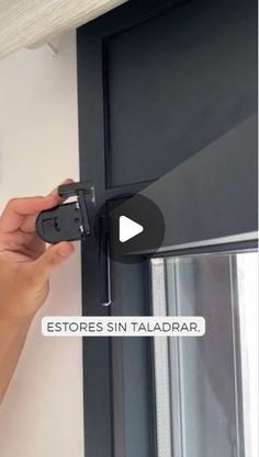 a person is holding a remote control in front of a door with the words estores sin taladrar on it