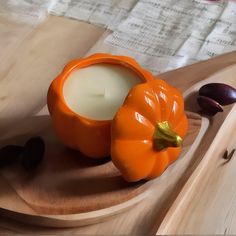 an orange candle sitting on top of a wooden tray