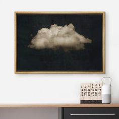 a black and white photo hanging on the wall next to a desk with a calendar