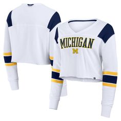 Elevate your Michigan Wolverines game day style with the Fanatics Training Camp Cropped Long Sleeve V-Neck Fashion Top. This cropped top is crafted from a supremely soft cotton-modal blend, making it an ultra-comfortable choice for game day or casual wear. With dropped shoulder seams, contrast-color sleeve insets and an on-trend cropped hem, it's as stylish as it is comfy. Sporty Tops For Game Day In Fall, Fall Sports V-neck Tops, Collegiate Tops For Sports Events, V-neck Tops For College Sports Season, Collegiate Tops For Fall Sports, College Style Sports Tops With Team Name, Collegiate Sports Tops For Fall, Fall School Spirit Team-colored Tops, Collegiate Tops With Team Name