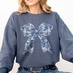 This Coquette Toile Bow sweatshirt makes a great gift for family, friends, coworkers and of course yourself! Luxurious comfort and style are what this unisex, garment-dyed sweatshirt is all about. It's made with 80% ring-spun cotton and 20% polyester and the fabric is 3-end garment-dyed, ring-spun, color-blast fleece with a 100% cotton face. Each sweatshirt comes with a relaxed fit, a rolled-forward shoulder, and a back neck patch.  .: 80% ring-spun cotton, 20% polyester .: Medium-heavy fabric (9.5 oz /yd² (322.1 g/m .: Relaxed fit .: Sewn in twill label .: OEKO-TEX certified low-impact dyes WASHING INSTRUCTIONS ▸ Wash inside out, in cold water, on gentle cycle. Tumble dry low or let air dry ▸ Do not use Fabric Softeners or Bleach ▸ Do not dry clean. Avoid ironing on the design. SIZE ▸ Tak Spring Cotton Sweatshirt Gift, Cute Blue Sweatshirt With Relaxed Fit, Casual Cotton Sweatshirt Gift, Casual Cotton Sweatshirt As Gift, Casual Cotton Tops As Gift, Casual Cotton Sweatshirt Perfect As A Gift, Casual Cotton Tops As A Gift, Cotton Tops As Fall Gift, Blue Casual Sweatshirt For Gift