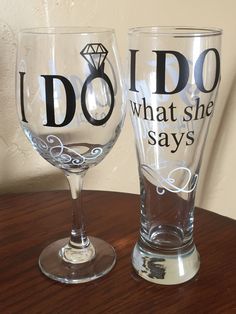 two wine glasses that say i do and what she says on them are sitting on a table