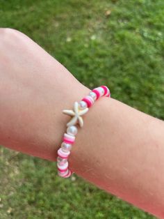 A handmade ombré pink clay bead bracelet with pearls and a starfish charm. Pink Starfish Jewelry For Gift, Pink Starfish Charm Jewelry, Pink Hand-strung Beaded Bracelets For Beach, Casual Beaded Bracelets With Starfish Charm, Pink Star-shaped Beaded Bracelets, Adjustable Pink Star Bracelets, Colorful Beads Starfish Bracelet As Gift, Starfish-shaped Bracelets With Colorful Beads As Gifts, Adjustable Starfish Beaded Bracelet