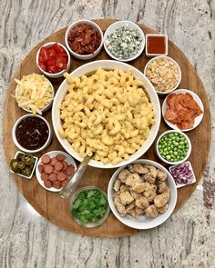 a wooden platter filled with different types of pasta and sauces on top of it