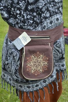 a close up of a person wearing a brown and black bag with a flower design on it