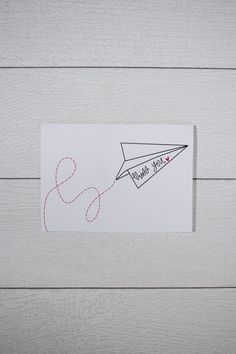 a piece of paper with the word love written on it and an airplane drawn in red ink