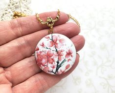 This beautiful cherry blossom locket is reminds the wearer of spring time and new life. A beautiful gift for someone special or a treat for yourself. Locket features a watercolor image that has been permanently printed on the front of the locket and is made to be scratch resistant. Locket measures: 1 1/4 inch in diameter unopened. The two inside areas for photos measure 1 inch in diameter. Every piece is handcrafted in my home jewelry studio and is one of a kind. Your locket will come in a gift Butterfly Locket Necklace, Summer Pendant, Gift Box For Men, Pink Cherry Blossom, Pink Cherry, Watercolor Images, Jewelry Studio, Layering Necklace, Blue Butterfly