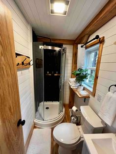 a bathroom with a sink, toilet and shower in it's own cabin style home