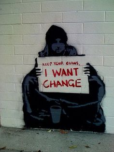 a person holding a sign that says i want change on the side of a building