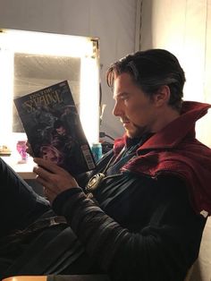 a man sitting in a chair reading a book