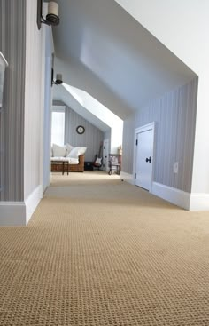 an attic bedroom with carpeted flooring and white walls