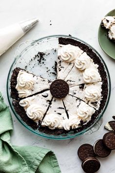 an oreo cookie cake with white frosting and oreos on the plate next to it