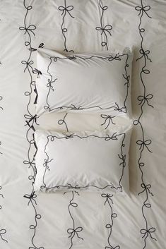 two white pillows sitting next to each other on a bed