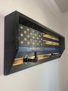 an american flag is hung on the wall with a blue line and firefighter's name