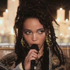 a woman with dreadlocks holding a microphone