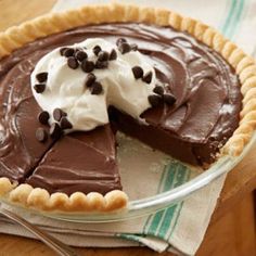 a chocolate pie with whipped cream and chocolate chips on top, ready to be eaten