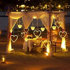 a table set up with candles and hearts on it