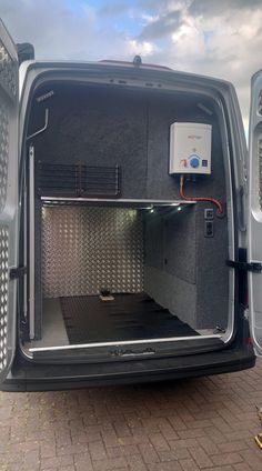 the back end of a van with its doors open and an air conditioner in it