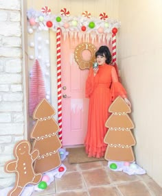 a woman standing in front of a door decorated with gingerbreads