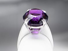 This exceptional amethyst commands attention! Generous in size, this gemstone sparkles with juicy hues of violet, fuchsia, and royal purple. A simple setting of 18 karat white gold lets the amethyst be the star of the show. Metal: 18K White Gold Gem: Amethyst 12.20 Carats Gem Measurements: 12.9 x 16.9 mm, Oval Ring Size: 6.25 Marks: "750" Stamped on the inside band Formal Purple Amethyst Solitaire Ring, Formal Purple Solitaire Amethyst Ring, Formal Purple Diamond Cut Jewelry, Formal Purple Jewelry With Polished Finish, Elegant Purple Platinum Jewelry, Hallmarked Purple Amethyst Ring With Round Cut, Purple Amethyst Ring Hallmarked Round Cut, Hallmarked Purple Amethyst Round Cut Ring, Classic Purple Amethyst Ring With Polished Finish