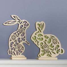 two wooden rabbits sitting on top of a shelf